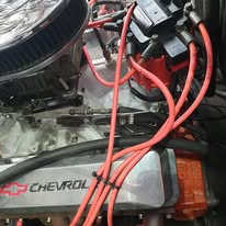 Chevrolet engine bay with red plug leads, classic rebuild